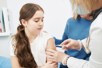 Little girl getting vaccine injection in clinic