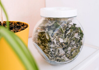 Storing dried raspberry leaves in a glass jar on the top shelf
