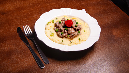 beef stew with mashed potatoes on wooden table