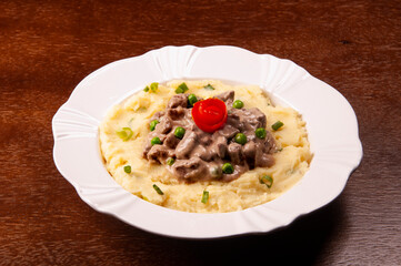 beef stew with mashed potatoes on wooden table