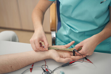 Female doctor examining male hand in clinic