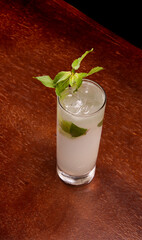 mojito cocktail in long drink with mint and ice top view on wooden table