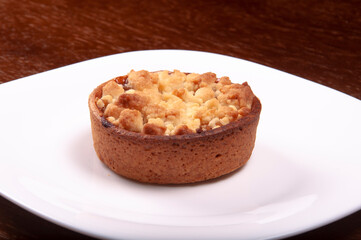 white plate with small apple pie on isolated table, closeup wood