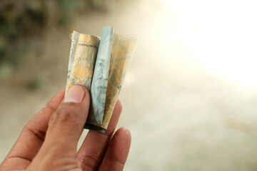 Hand holding rupiah banknote