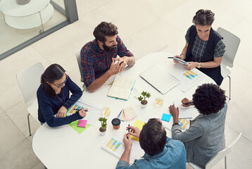 Obraz premium Incorporating all the best ideas into their design solutions. Shot of a group of creative businesspeople having a meeting in an office.