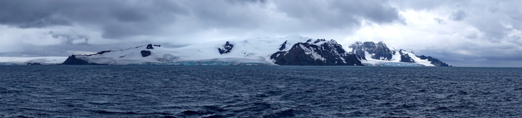 Fototapeta na wymiar Panorama of rugged, snow covered peaks and glaciers in Antarctica