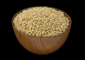 Wooden bowl with wheat seeds isolated on black 