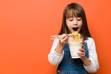 Cute little girl eating ramen noodles