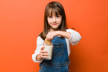 Cute little girl loves milk and cookies - Powered by Adobe