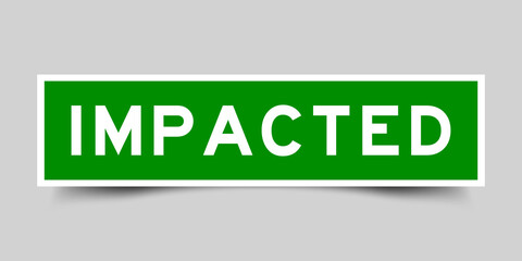 Sticker label with word impacted in green color on gray background