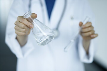 Close up of doctor holding test tube and flask. Biotechnology, medicine, chemistry concept.