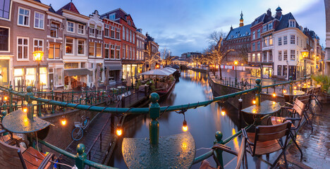 Beautiful old houses and illumination on the Leiden city embankment at sunset.