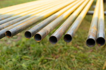 Pipes lie in row. Steel parts. Yellow pipes for gasification.