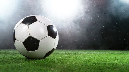 Fototapeta premium Soccer ball on grass with dark background and lights