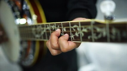 Banjo player playing traditional Irish melodies, close up and bokeh
