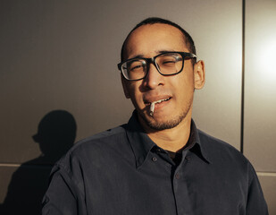 Obraz premium Man smoking a white paper joint close up.