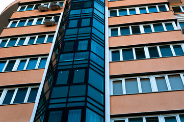 Exterior of a modern multi-story apartment building. Facade, windows and balconies.