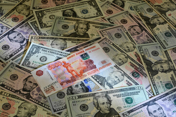 Russian banknote of 5000 rubles against the background of United States dollar banknotes
