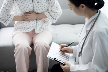 Doctor checking patient's stomachache in office