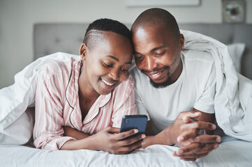 Theres more than one way to connect these days. Shot of a happy young couple using a smartphone...