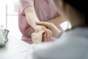Doctor checking patient's hand pain - obrazy, fototapety, plakaty