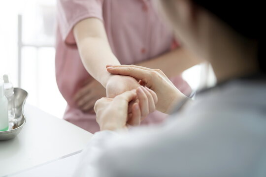 Doctor checking patient's hand pain