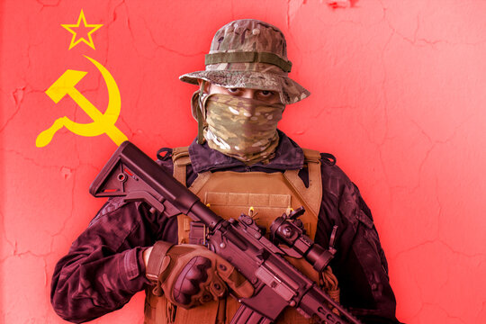 Angry soviet soldier armed with a rifle with soviet union flag as background behind