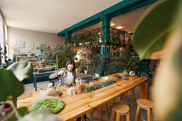 Adult lady making designer art object with flowers