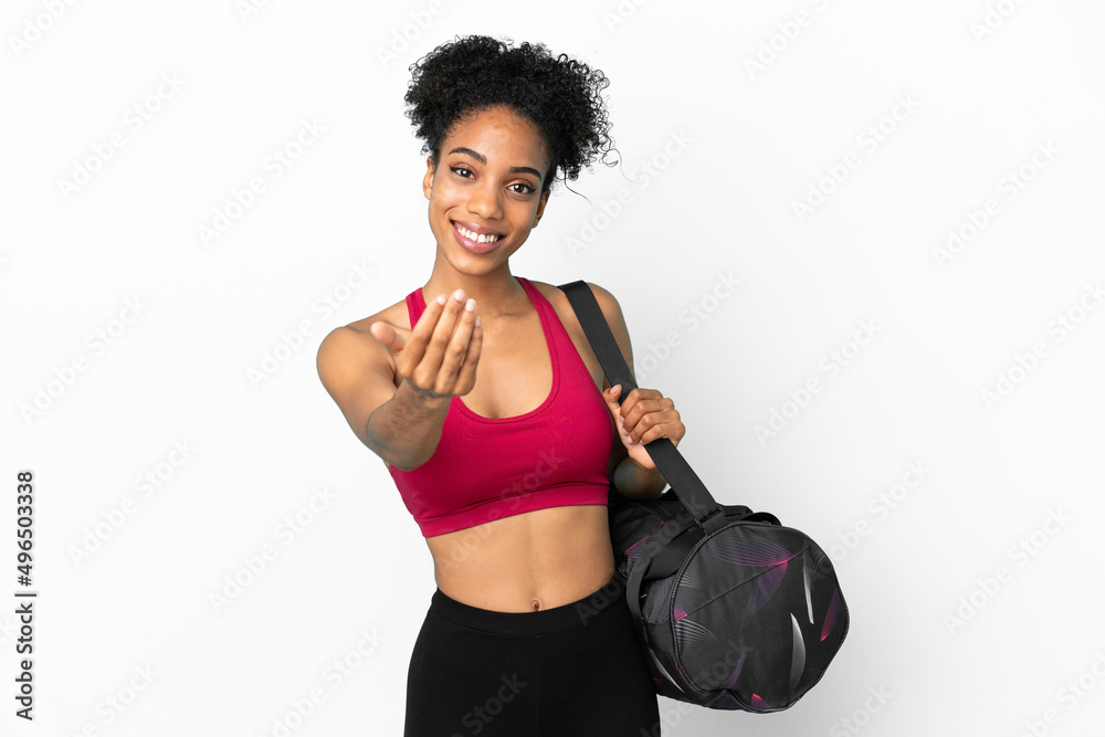 Canvas Prints Young sport african american woman with sport bag isolated on blue background inviting to come with hand. Happy that you came