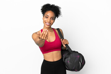 Obraz na płótnie Canvas Young sport african american woman with sport bag isolated on blue background inviting to come with hand. Happy that you came