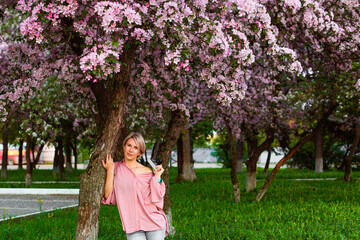 Fototapeta na wymiar Beautiful young lady in the garden of cherry blossoms