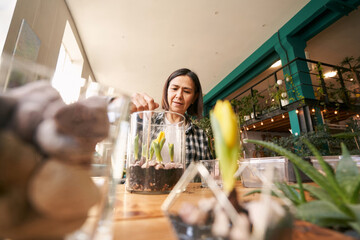 Woman is working in workshop , planting flowers