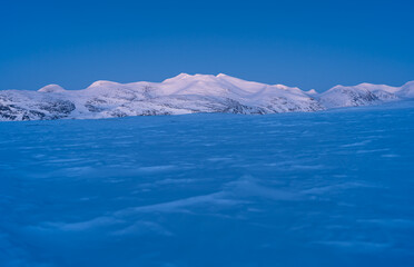 Fototapeta na wymiar Dusk in the snow covered mountains in Swedish Lapland, near the famous Kungsleden.