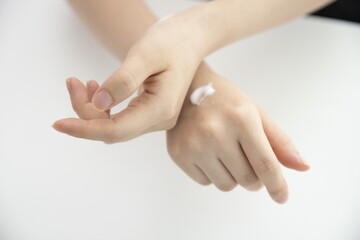 Young woman applying hand cream