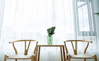 Table and two chairs in front of the window