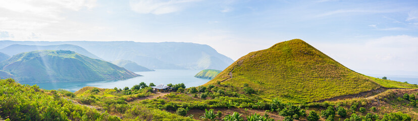 Lake Toba and Samosir Island view from above Sumatra Indonesia. Huge volcanic caldera covered by water, traditional Batak villages, green rice paddies, equatorial forest. - obrazy, fototapety, plakaty