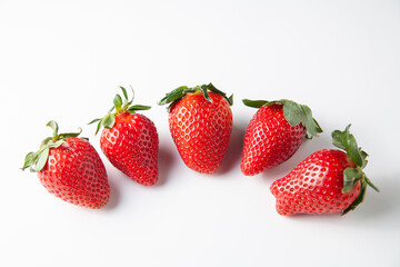 Five Strawberries are on the table. On a white background.