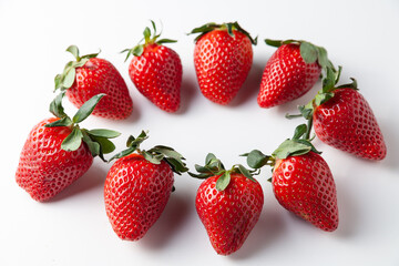 Strawberries lie in a circle on the table. On a white background. Selective focus.