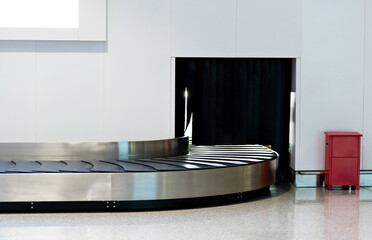 Suitcase or baggage on belt in arrivals lounge of airport terminal