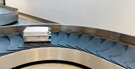 Suitcase or baggage on belt in arrivals lounge of airport terminal