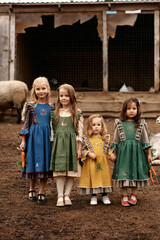Naklejka premium cute children in beautiful green dresses walking on a farm