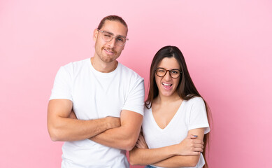 Young caucasian couple isolated on pink background With glasses and happy expression