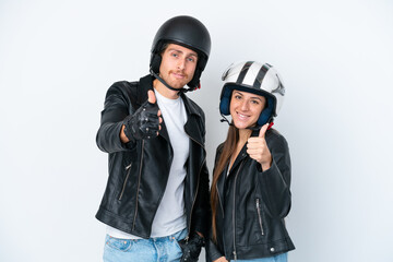 Young caucasian couple with a motorcycle helmet isolated on white background giving a thumbs up...