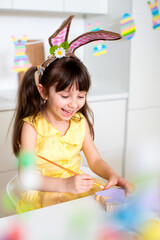 A cute smiling girl of 6 years old paints colorful eggs for the Easter holiday. Christian religion. Ukrainian Orthodoxy