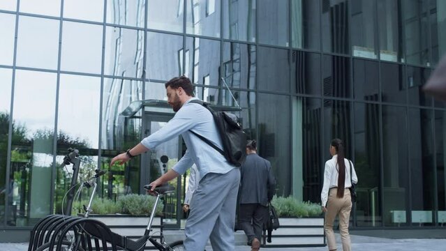 Manager riding bicycle leaving office workplace. Modern city mobility vehicle.