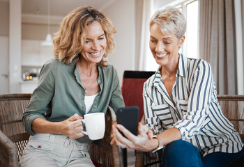 Your grandson has grown so much. Shot of two female friends drinking coffee while using a digital...