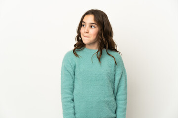 Obraz premium Little caucasian girl isolated on white background having doubts while looking up