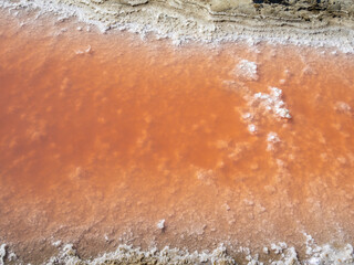 Orange water and white salt close-up, Giraud salt pans, France