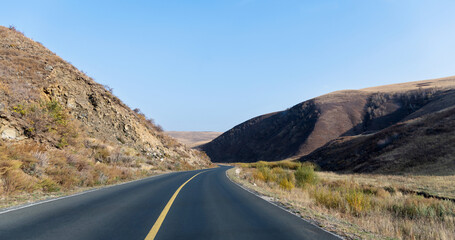 Country road through the hill in the autumn