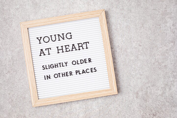 Obraz premium Letter board with text young at heart, slightly older in other places. Ageing concept